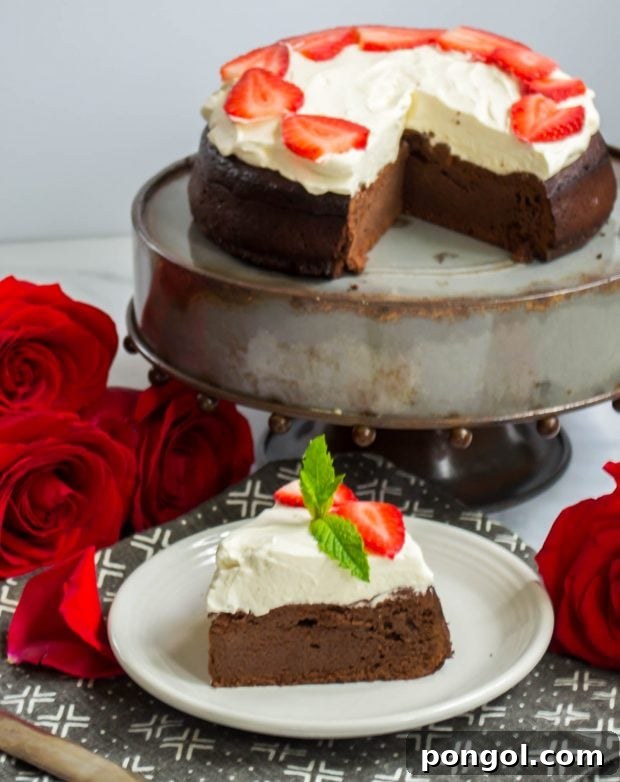 keto flourless chocolate cake on a cake stand with one slice cut, revealing its dense, rich texture