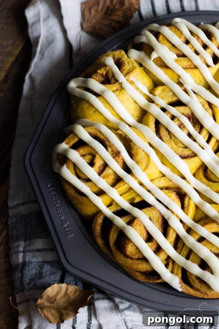 Warm and inviting Vegan Pumpkin Cinnamon Rolls, generously topped with a rich maple-cream cheese glaze, simplified for quick preparation (about 2 hours) and ideal for a fall breakfast.