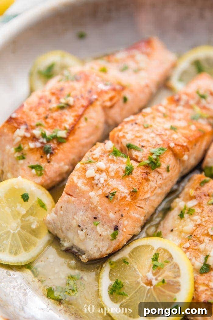 Lemon garlic salmon in a skillet with lemon slices, a healthy and delicious meal.