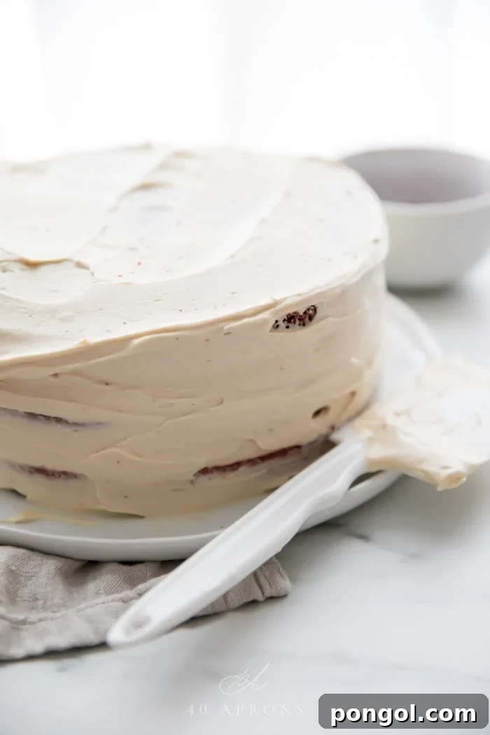 A crumb coat on a gluten free red velvet layer cake with paleo cream cheese frosting