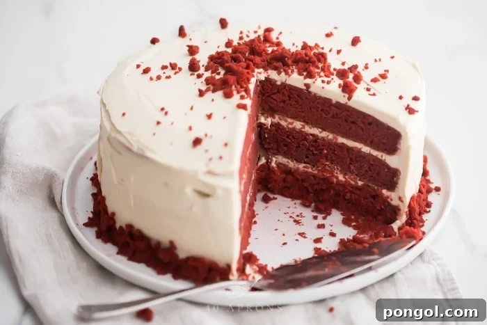Three layer gluten free red velvet cake with paleo cream cheese frosting sliced open 