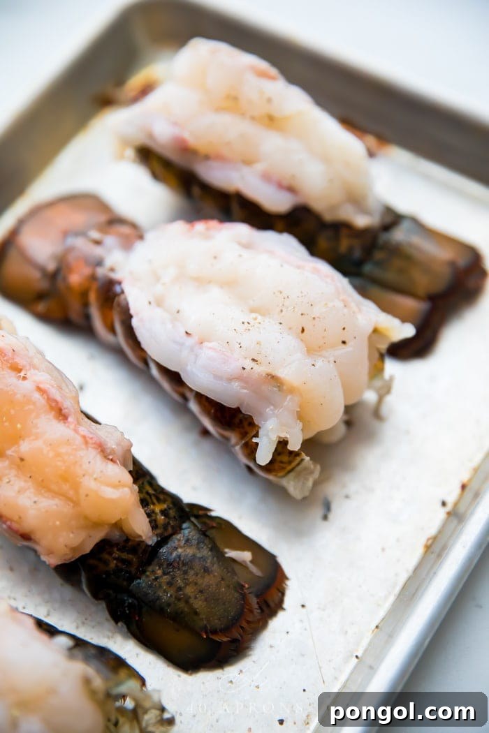 Butterflied lobster tails on a baking sheet