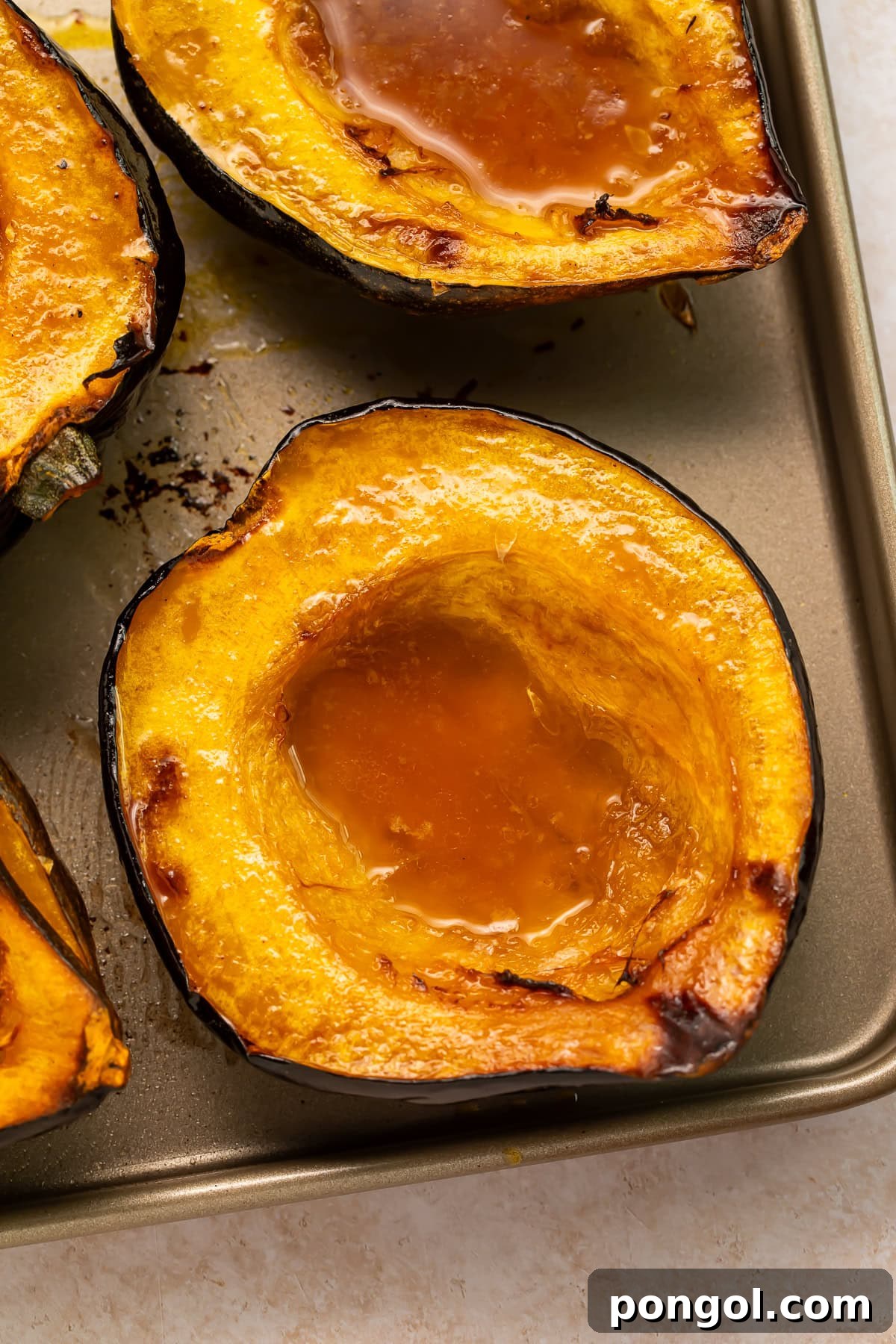 Golden roasted acorn squash halves showing caramelized edges and maple butter glaze