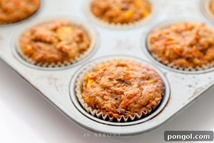 Delicious Paleo Carrot Cake Cupcakes Free From Gluten and Dairy 9 Baked, unfrosted carrot cake cupcakes in a silver metal muffin pan.