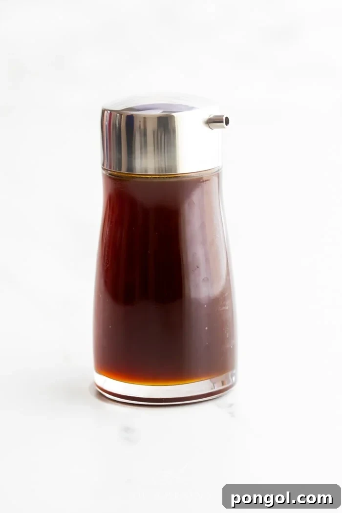 A bottle of healthy soy sauce substitute with a silver pour top, ready for use.