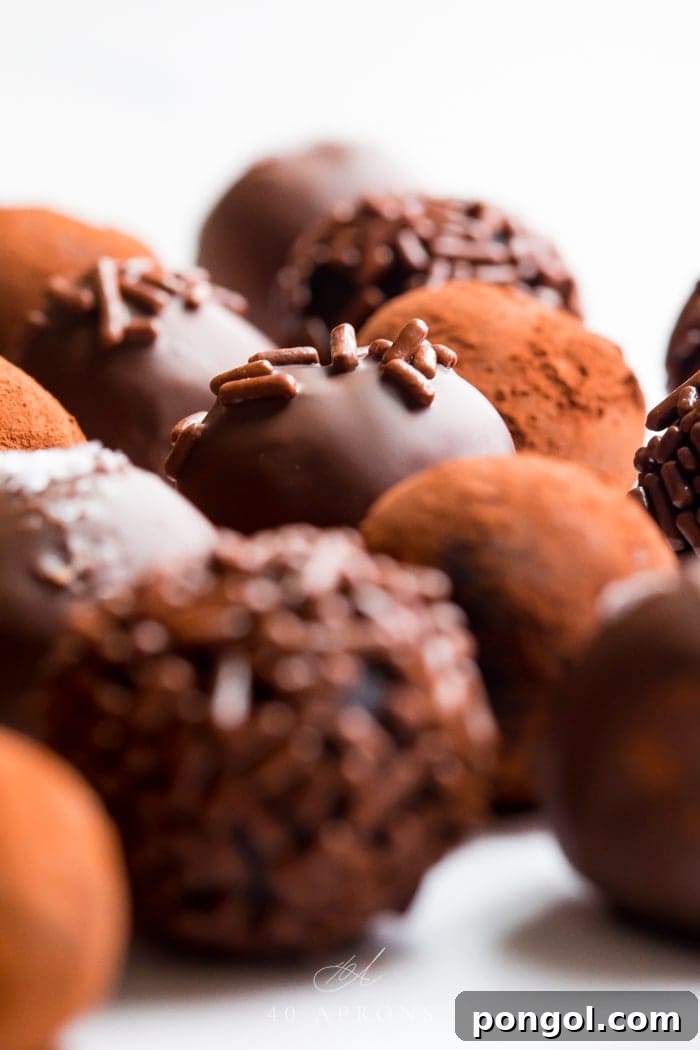 A stunning close-up of healthy vegan chocolate truffles with various coatings, highlighting their rich, dark chocolate color and smooth texture.