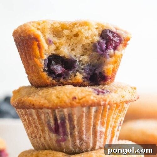 Blueberry muffins stacked with a bite out of one