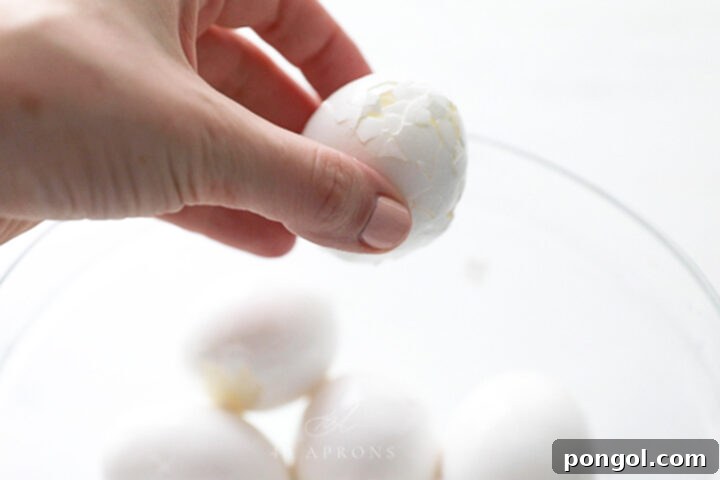A boiled egg with a very cracked shell ready to peel.