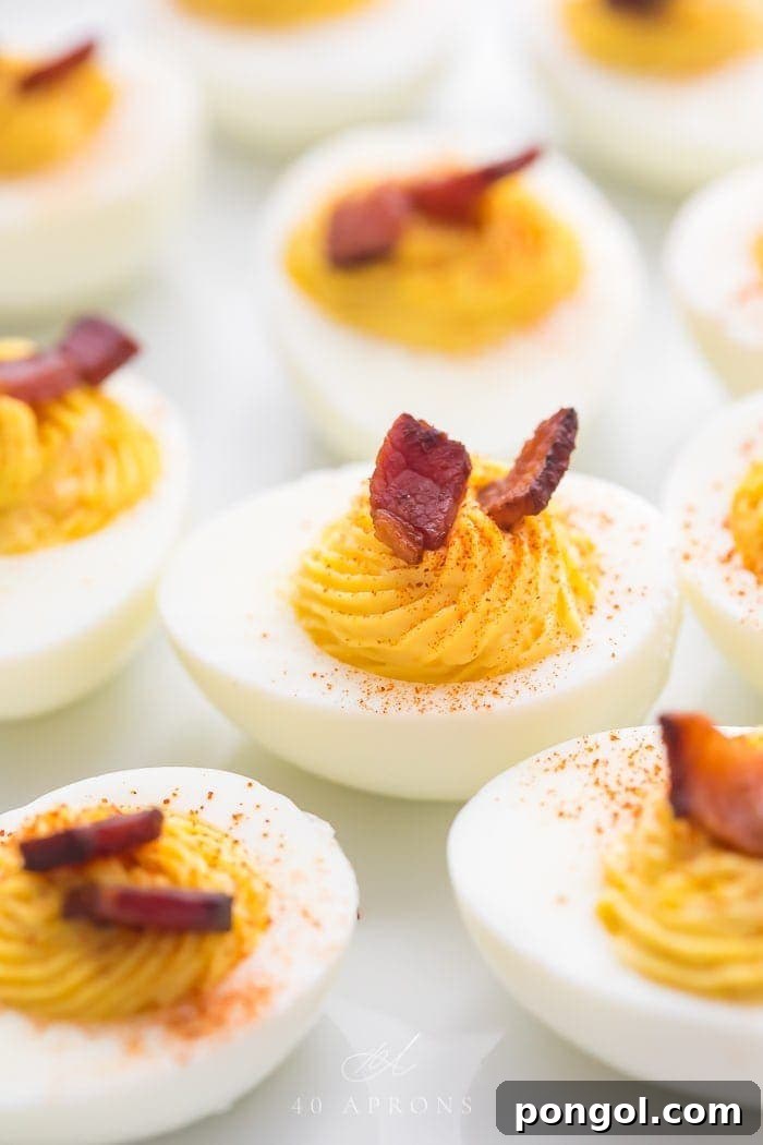 Deviled egg with crispy bacon on top, surrounded by more deviled eggs
