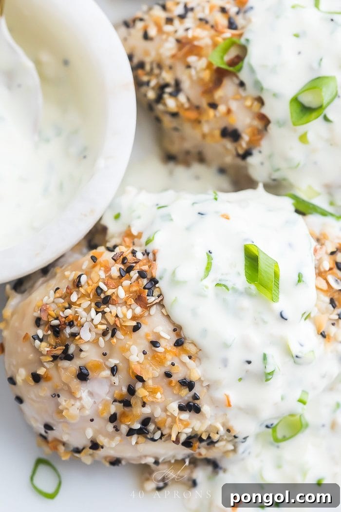 Close up of chicken breasts coated in everything bagel seasoning with cream cheese sauce