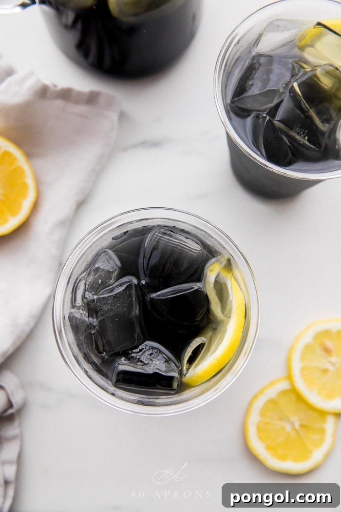 Two glasses of charcoal lemonade from an overhead perspective, highlighting the dark color and simple presentation