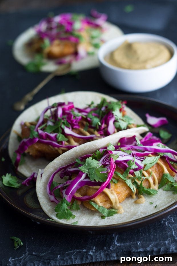An enticing close-up of Beer Battered Tofu Tacos with a creamy Chipotle Aioli, served fresh and vibrant on a platter, showcasing a delicious vegan meal.