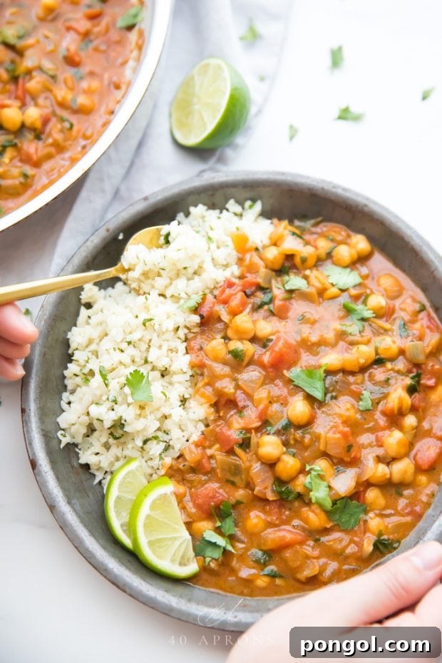 A beautifully presented bowl of quick, creamy vegan coconut chickpea curry, garnished with fresh herbs and served with rice, highlighting a flavorful and healthy plant-based dinner.