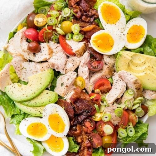 A classic healthy chicken cobb salad on a white plate