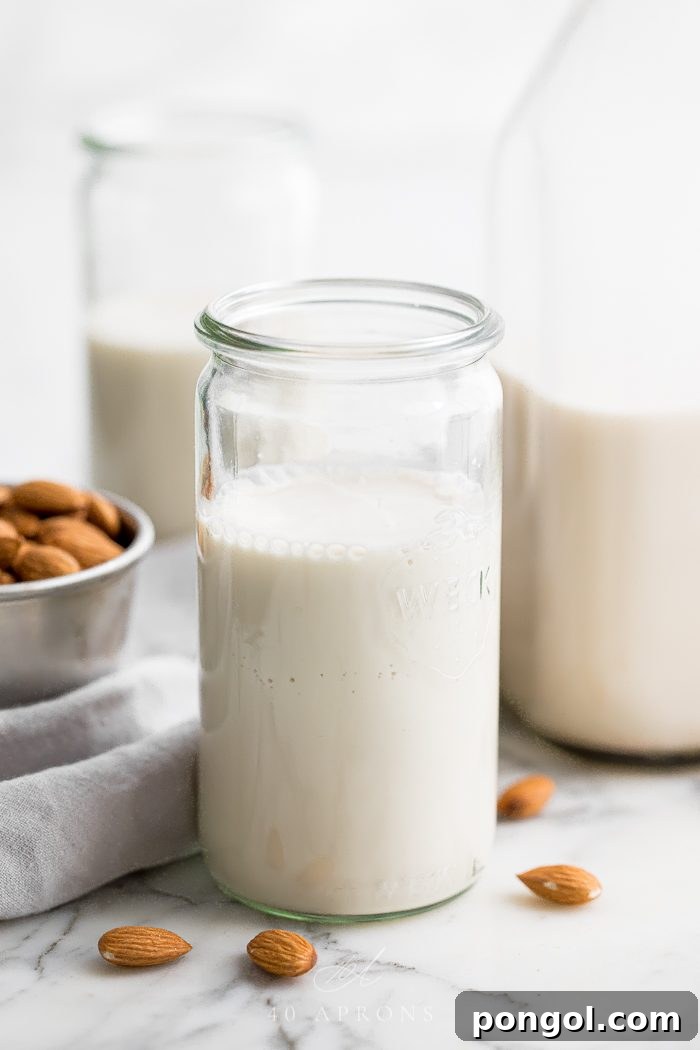 Homemade almond milk in a jar with other containers in background