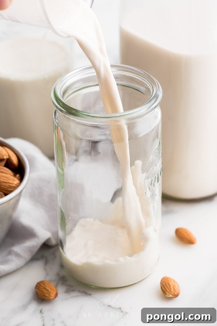 Homemade almond milk pouring into a jaar