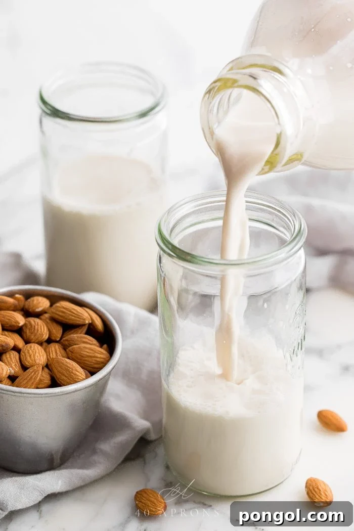 Homemade almond milk pouring into a jar