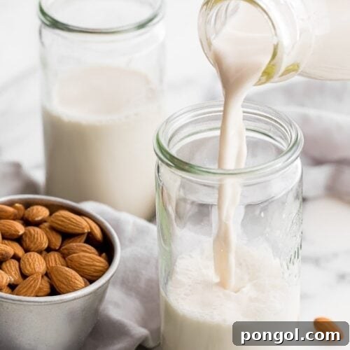 Homemade almond milk pouring into a jar