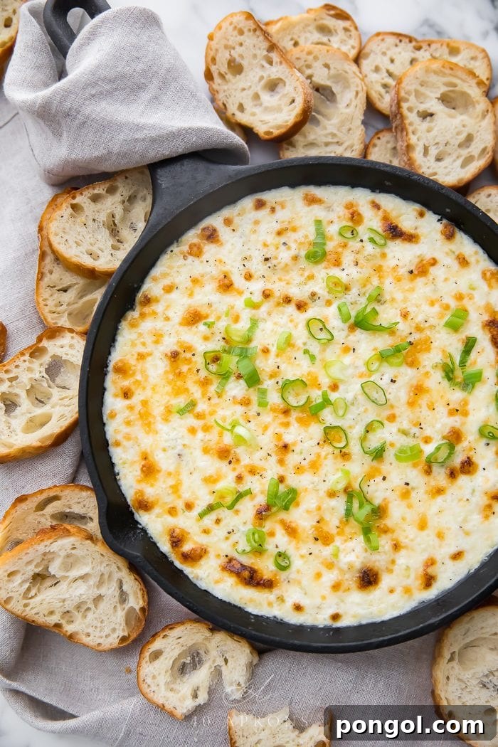 Crab dip in a skillet surrounded by crostini, ready to be served