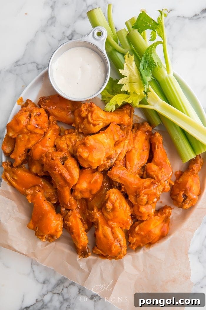 Crockpot chicken wings on parchment paper with celery and blue cheese