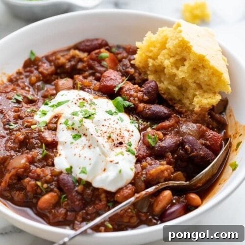 A bowl of vegan chili with a piece of cornbread
