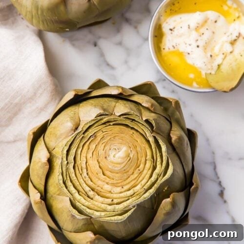 A cooked instant pot artichoke on a marble work surface