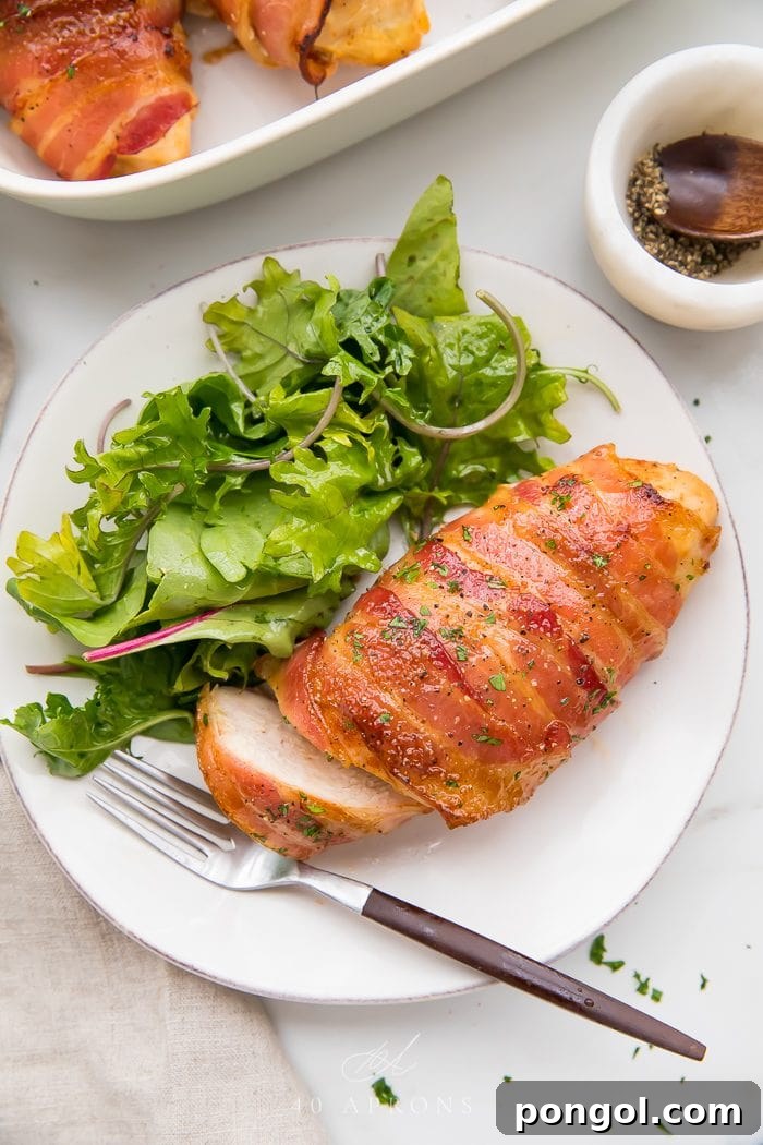 Chicken and salad served on a white plate, showcasing the crispy bacon and delicious crust.