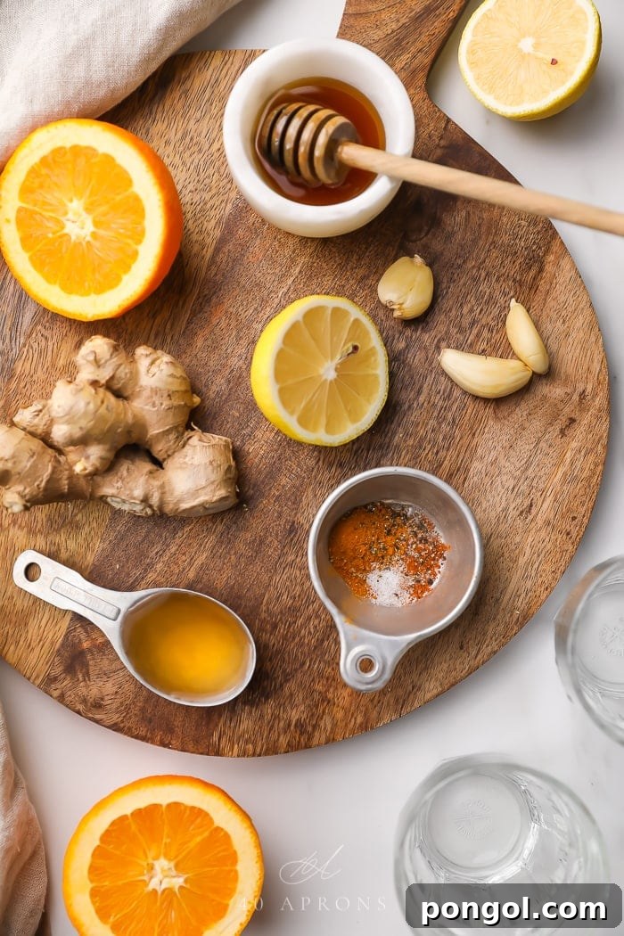 Fresh ingredients laid out on a wooden surface, including garlic, ginger, lemons, oranges, and jars of honey and apple cider vinegar, ready to make the immune booster shot.