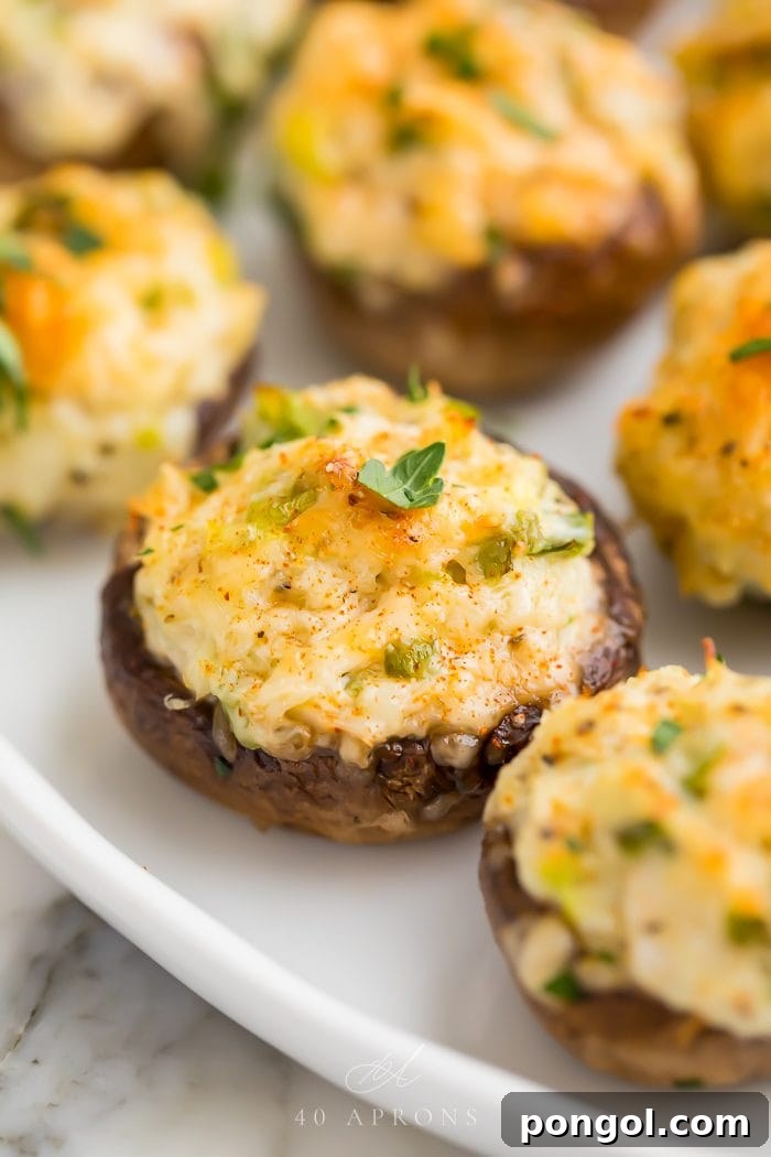 Stuffed mushrooms on a white plate ready to serve, showcasing golden-brown tops and creamy filling