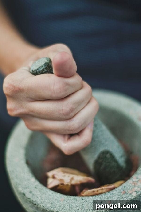 Adaptogenic mushrooms being carefully ground in a traditional granite mortar and pestle, symbolizing ancient wisdom and natural preparation.