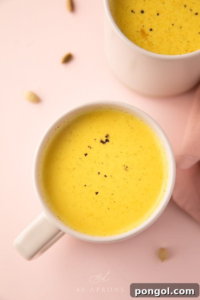 A close-up shot of a creamy, golden-colored drink in a pristine white mug, steam gently rising, evoking warmth and comfort.