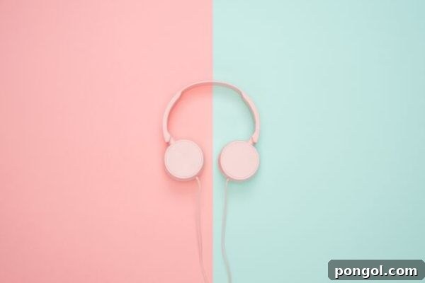 A pair of pastel pink headphones placed delicately on a soft pastel blue and pink gradient background, suggesting relaxation, music, or listening to audio content as a form of self-care.