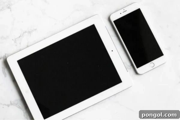 A minimalist setup featuring a turned-off white tablet and a sleek white smartphone resting on a pristine marble countertop, symbolizing a moment of digital disconnection and peace.