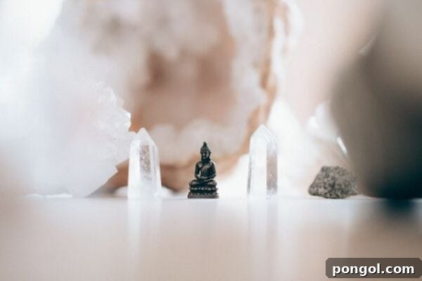 A serene arrangement featuring a small, golden brass Buddha statue positioned between two shimmering crystals, creating an atmosphere of calm and spiritual balance.