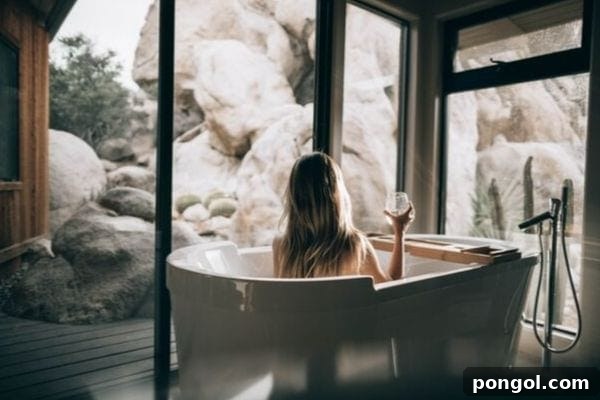 A woman luxuriating in a bathtub, holding a wine glass, amidst a soothing ambiance. The scene suggests deep relaxation and self-indulgence as part of a home spa experience.