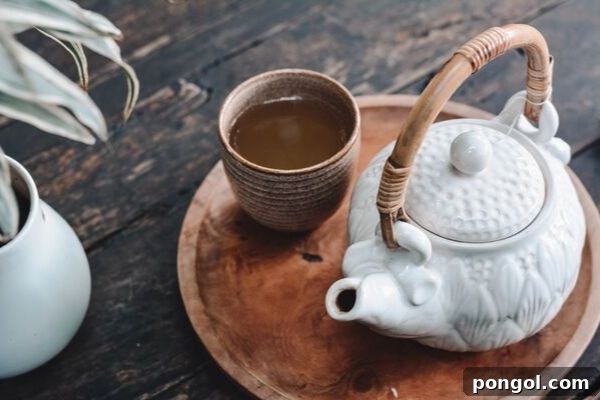 A beautifully crafted white Japanese teapot rests on a rustic wooden tray, accompanied by a matching teacup. The serene setup invites a moment of calm and reflection, perfect for a tea ritual.