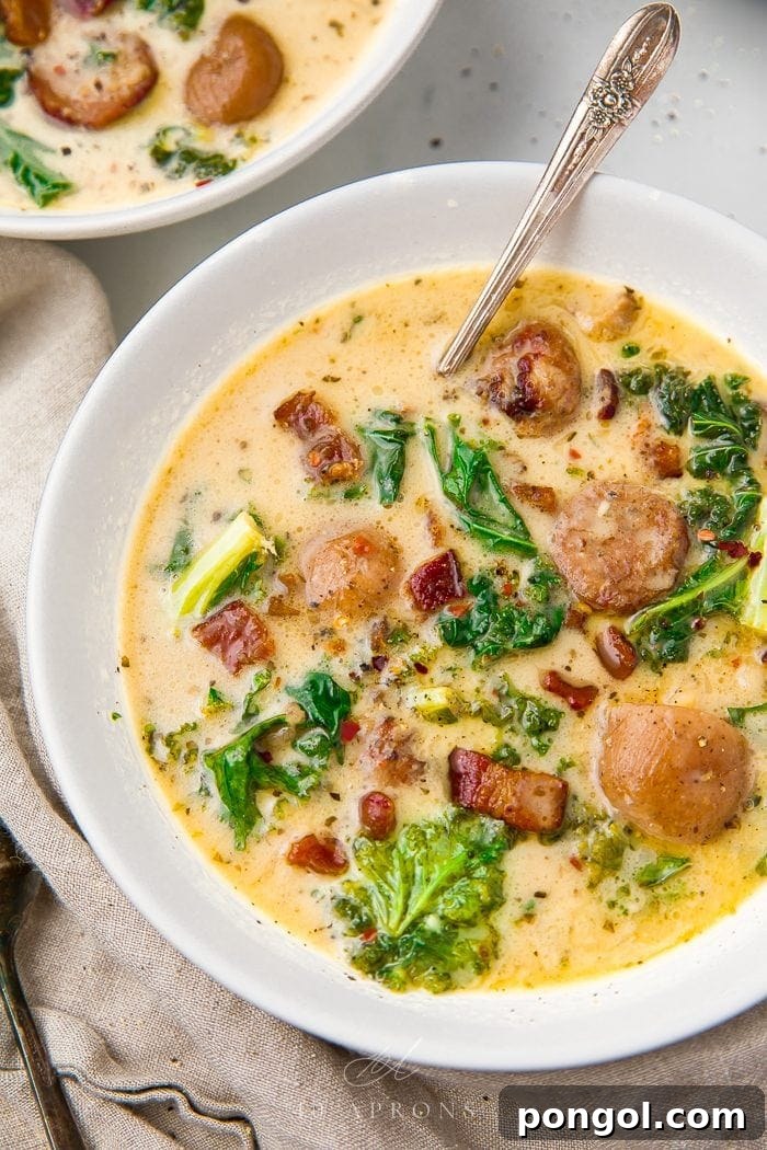 Hearty Whole30 Crockpot Zuppa Toscana 2 A steaming bowl of creamy Crockpot Zuppa Toscana, garnished with fresh parsley and served with a spoon on a rustic wooden table.