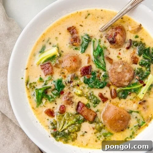 Hearty Whole30 Crockpot Zuppa Toscana 4 A close-up of a serving of Crockpot Zuppa Toscana in a white bowl, ready to be enjoyed.