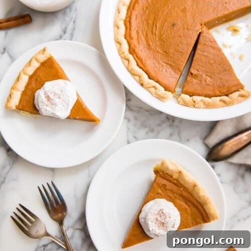 Slices of vegan pumpkin pie served with cream on white plates