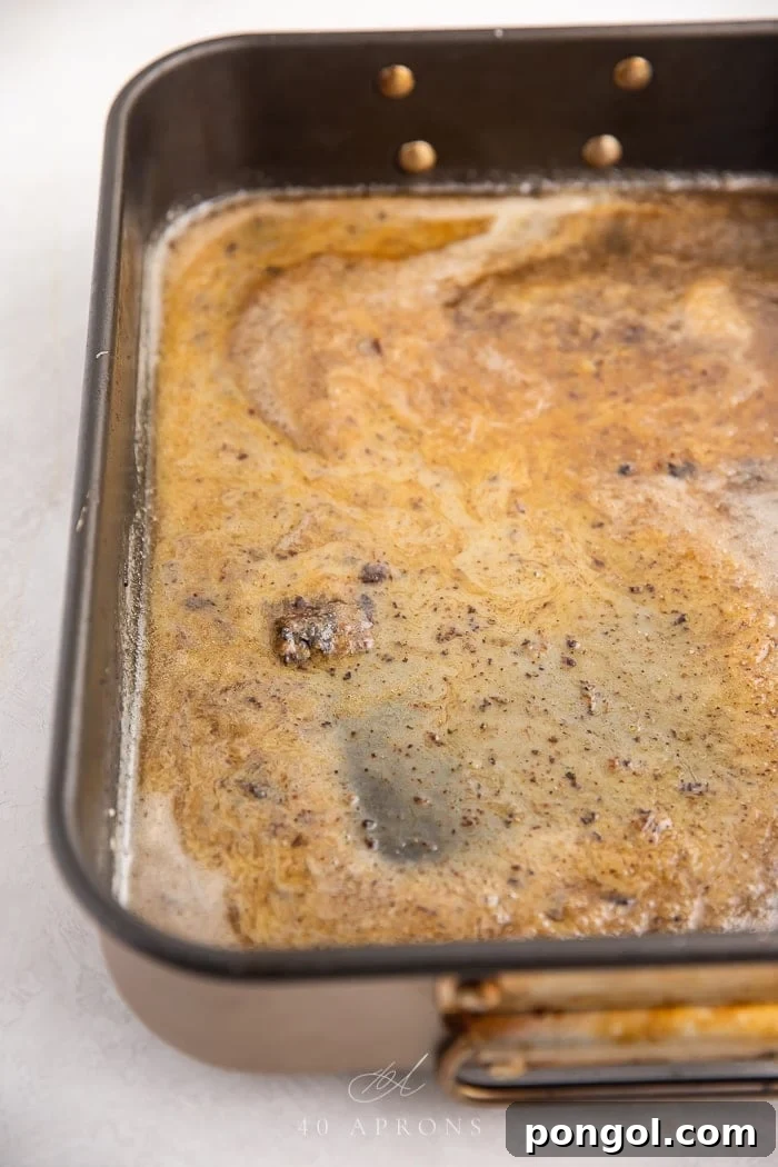 Rich, savory gravy simmering in a roasting pan, ready to be strained and served alongside the holiday turkey.