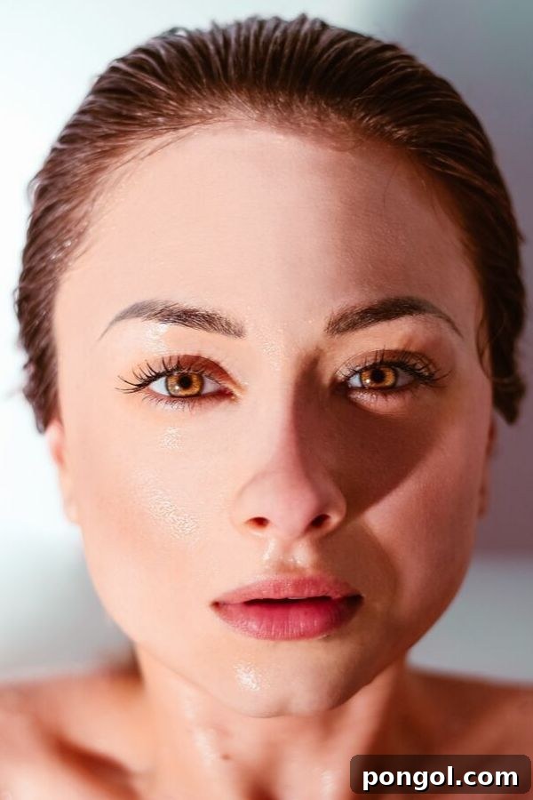 a clear skinned brown-eyed woman with a freshly washed face that is still wet