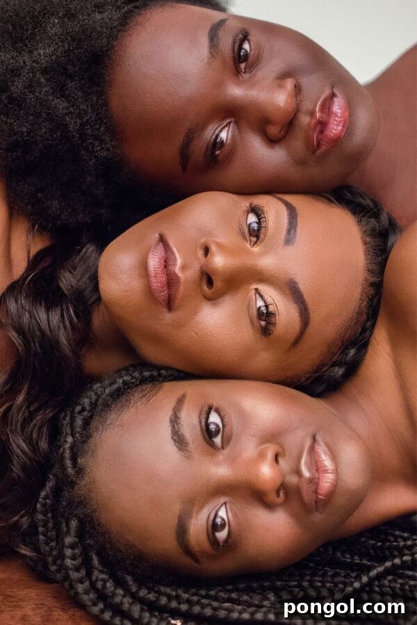 three dark skinned women with very clear skin lying next to each other in a line with their faces facing upwards