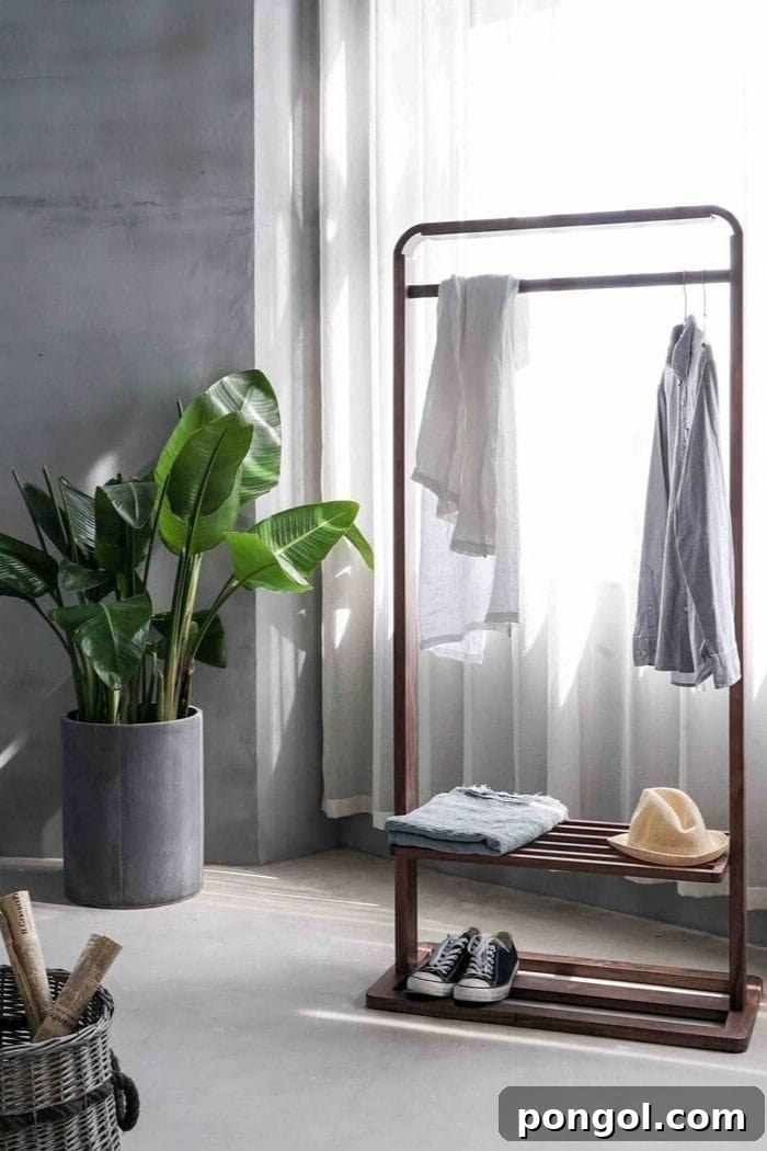 a minimalistic wardrobe with just the most basic items with a big plant next to the clothes rack