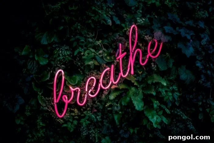 Effortless Detox: 8 Yoga Poses to Cleanse Your System 11 a pink neon sign spelling the word breath with greenery in the background