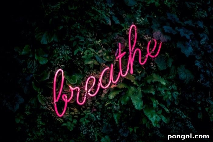 a neon pin sign reading the word breathe against a background of jungle plants