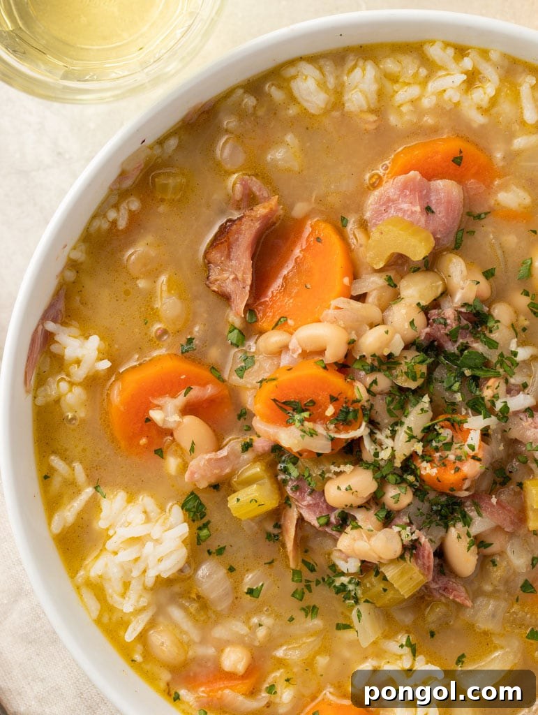An inviting overhead view of a steaming bowl of Smoked Turkey and White Bean Soup, garnished simply, emphasizing its wholesome and comforting appeal.