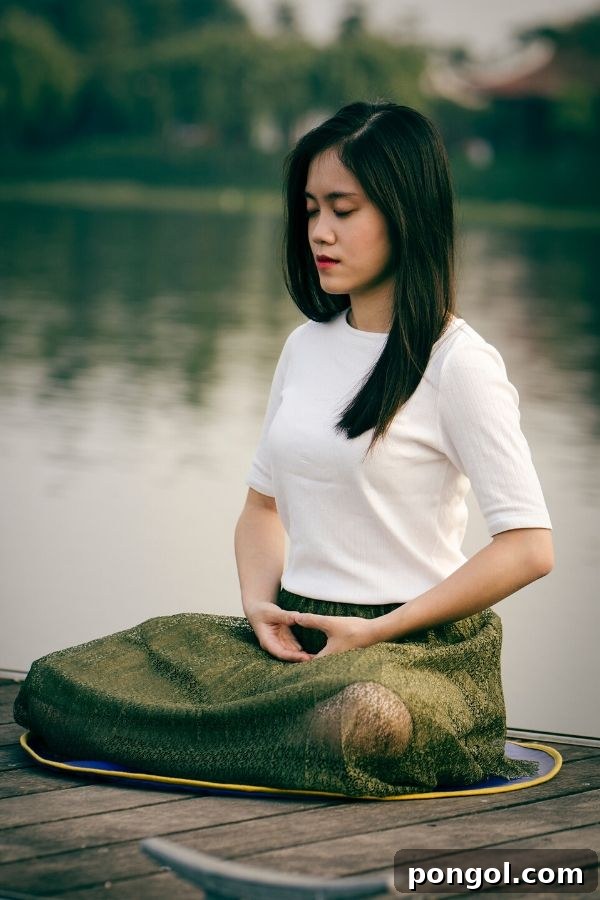 Quick Calm for Holiday Chaos 4 a young Asian woman meditating sitting in the lotus position on the pier of a lake