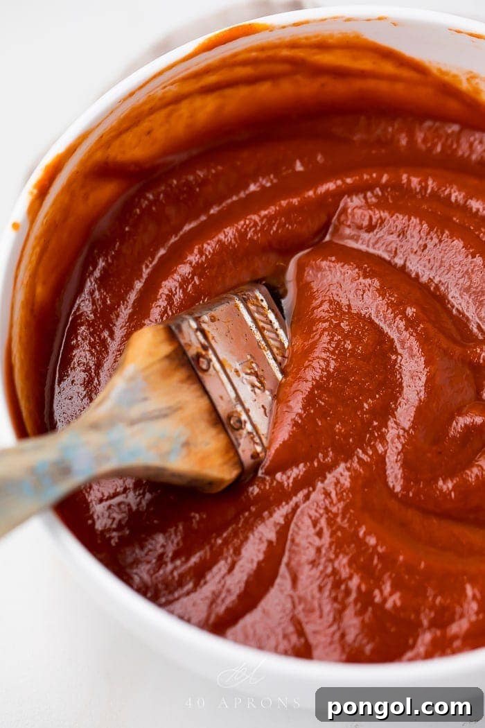 A bowl of the whole30 bbq sauce with a brush in it