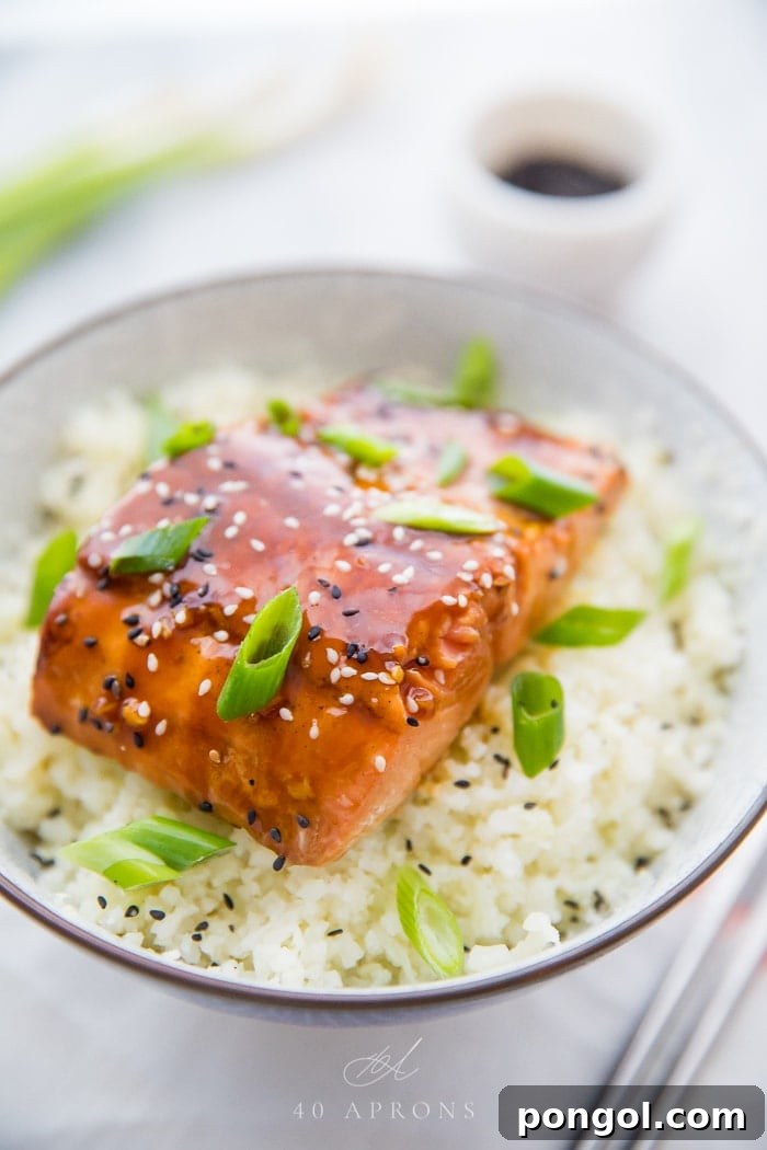 Teriyaki salmon garnished with vibrant green onions and sesame seeds, ready to be enjoyed