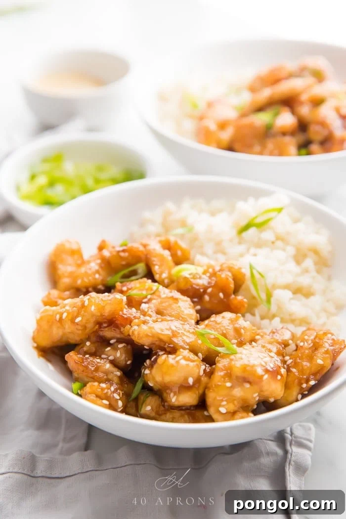 Wholesome Whole30 Sesame Chicken 4 Sesame chicken served in a white bowl with cauliflower rice